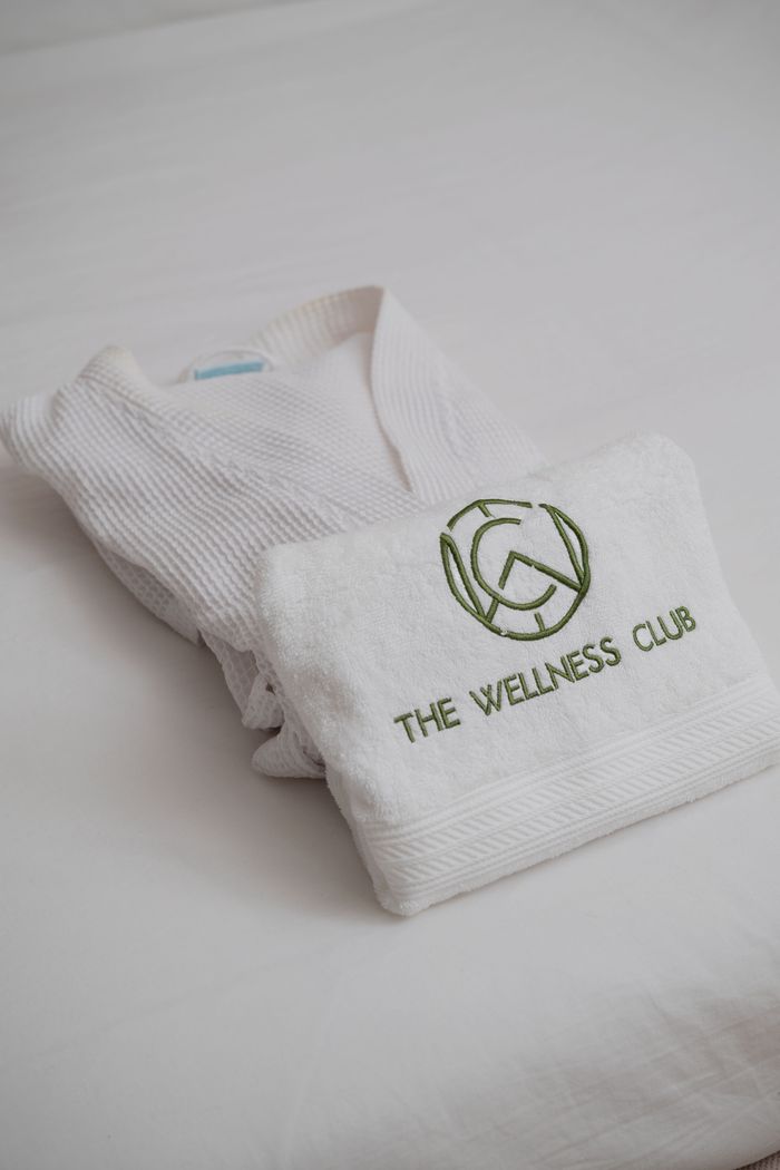 Elegant white spa robe and embroidered towel set at The Wellness Club in Abuja, Nigeria.