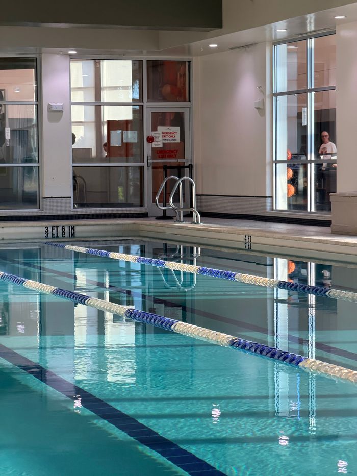 Peaceful indoor swimming pool with clear reflections, gym environment, Pompano Beach.